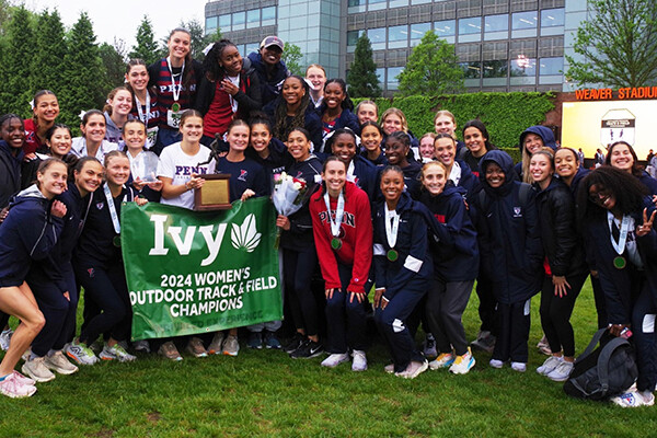 Women's track and field members pose with the championship banner.